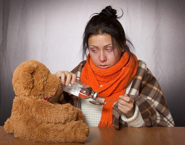 žena s chřipkou dává lék medvídkovi